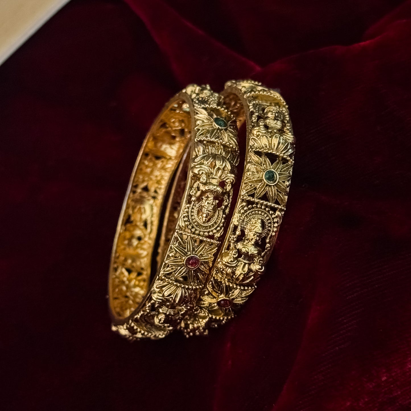 premium antique gold temple bangles featuring continuous rows of sculpted goddess lakshmi motifs square green stones and maroon halos