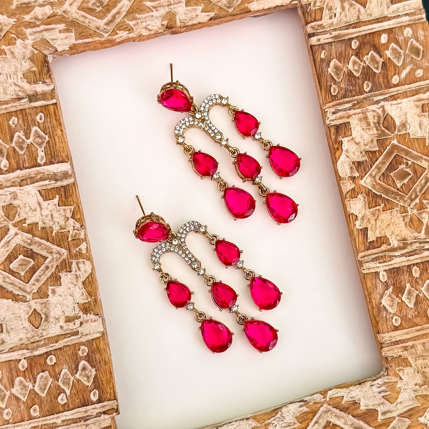 Sharon premium gold chandelier earrings featuring a micro pave crystal arch and cascading tracks of faceted hot pink teardrop crystals