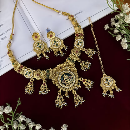premium antique gold kundan necklace set featuring a multi strand tracking of white pearls and green beads a large central circular medallion with red and green stones and matching rectangular tiered drop earrings