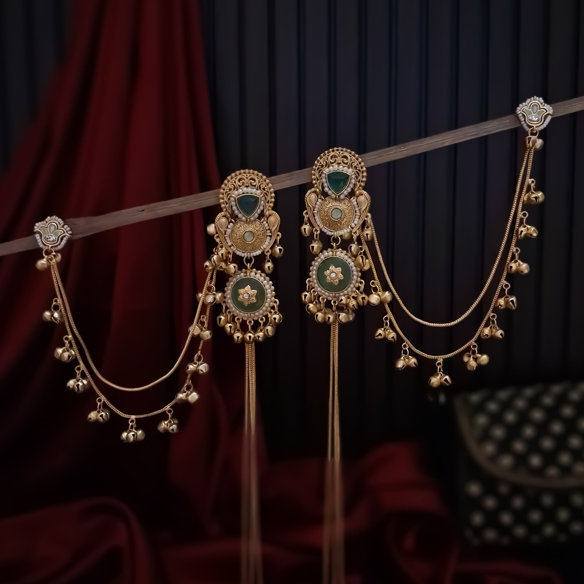 Yukti premium matte gold kashmiri earrings featuring ruby meenakari teardrop studs dual circular medallions white pearl frames long vertical ghungroo tassel chains and a detachable double strand bell sahara hair chain