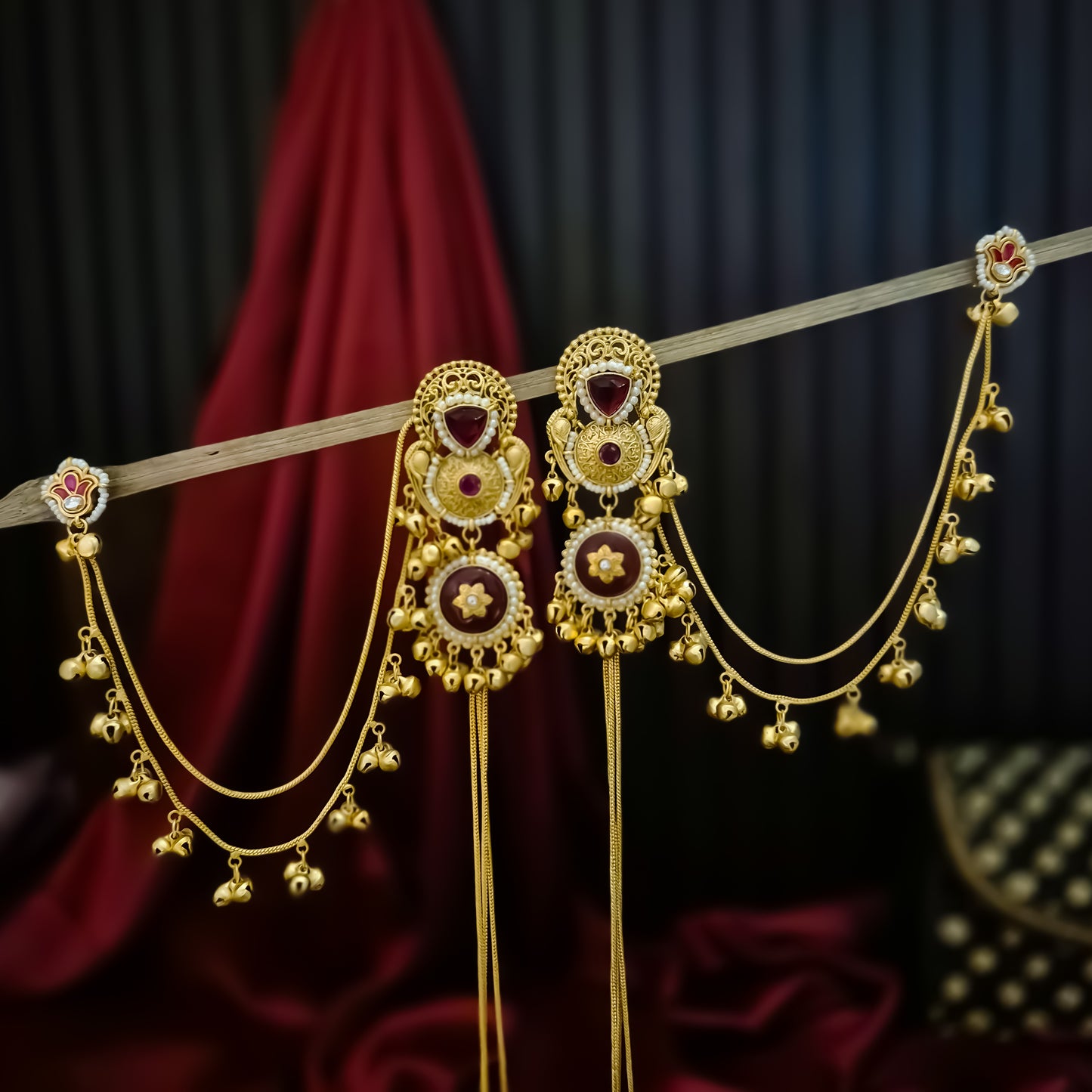 Yukti premium matte gold kashmiri earrings featuring ruby meenakari teardrop studs dual circular medallions white pearl frames long vertical ghungroo tassel chains and a detachable double strand bell sahara hair chain
