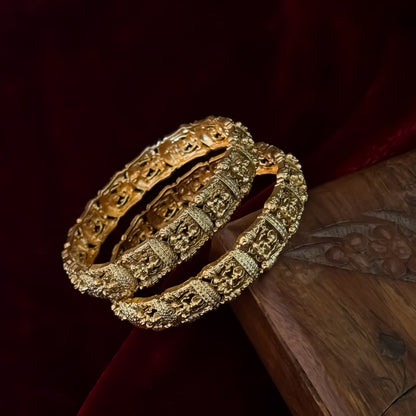 Tarakshi premium antique gold temple bangles featuring continuous rows of sculpted goddess lakshmi motifs in micro arches