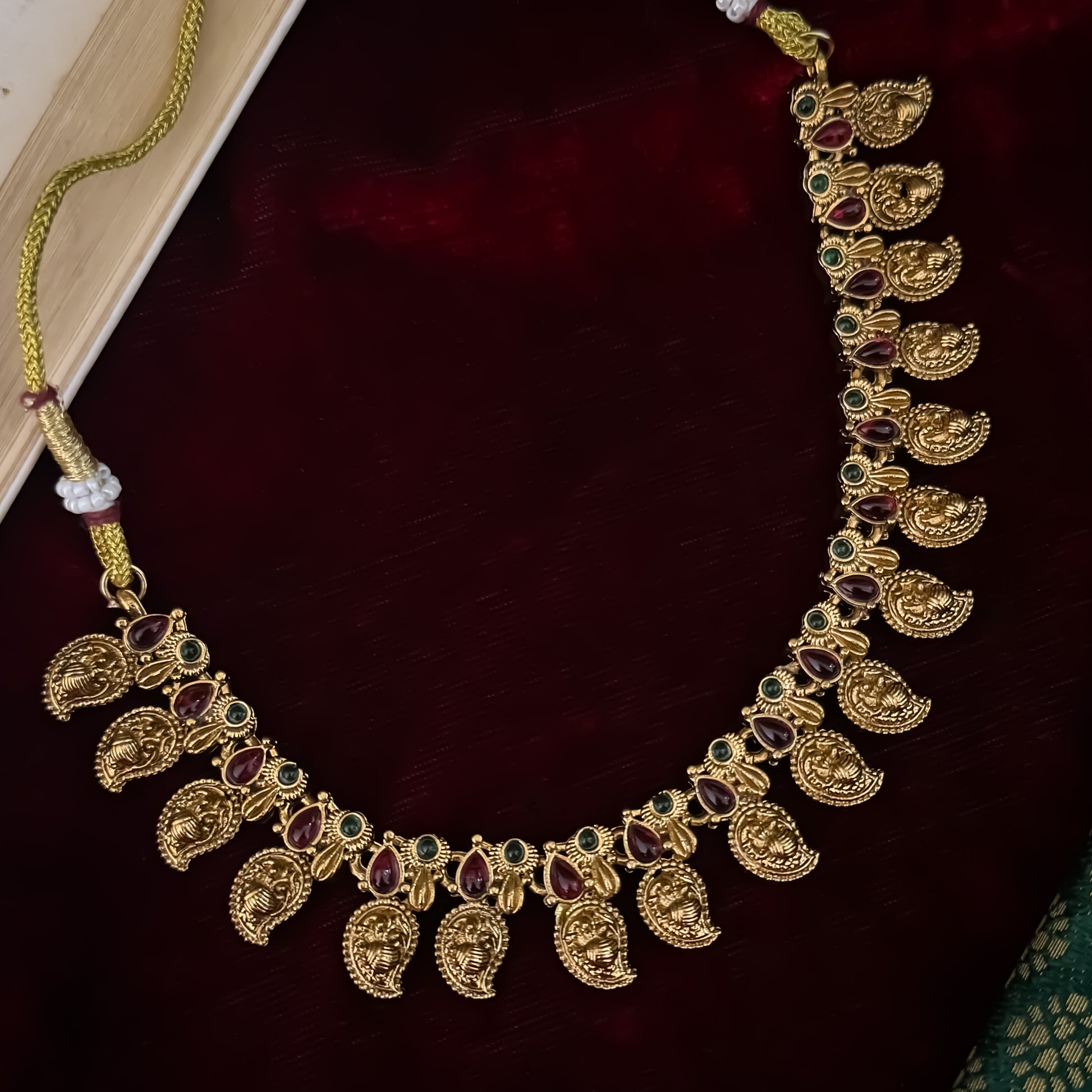 Amrapali leaf Temple gold temple choker necklace set featuring a continuous linked row of paisley manga medallions with alternating pink and green kemp stones alongside matching paisley drop earrings