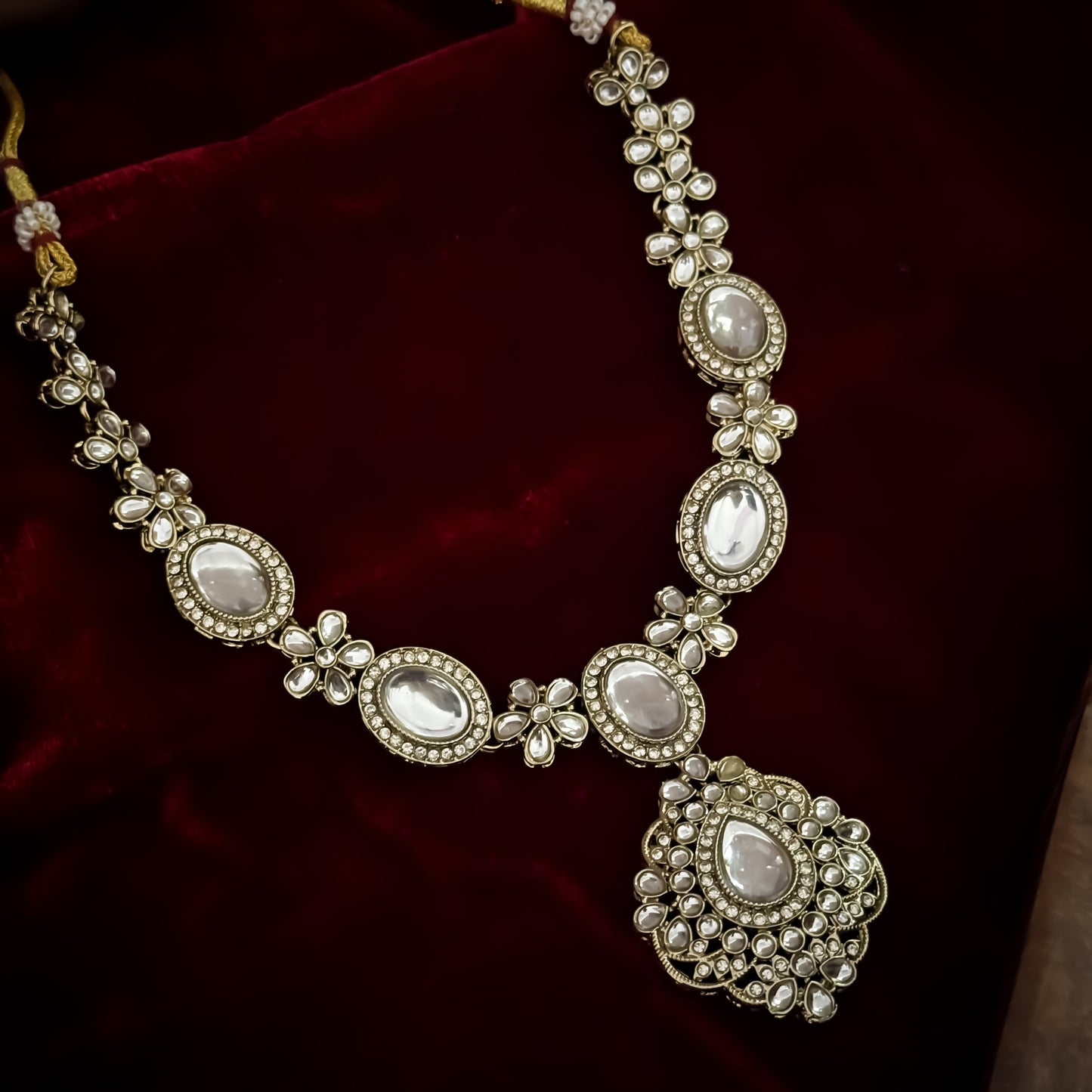 Golden Vanshika premium zircon kundan necklace set featuring oval stone links floral clusters large shield pendant matching earrings and maang tikka