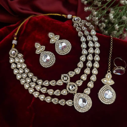 Rashmika premium antique gold kundan triple layer necklace set featuring three parallel cascading tracks of clear dabi mock polki stones a central teardrop pendant line matching drop earrings and maang tikka
