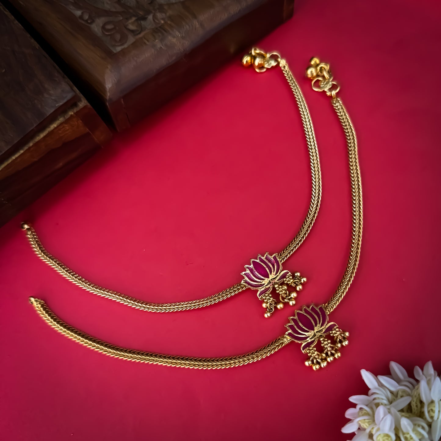 Lotus Bairagi premium antique gold temple anklet pair featuring flexible double strand woven rope chains a hand painted pink meenakari lotus flower centerpiece and dangling gold ghungroo bell clusters