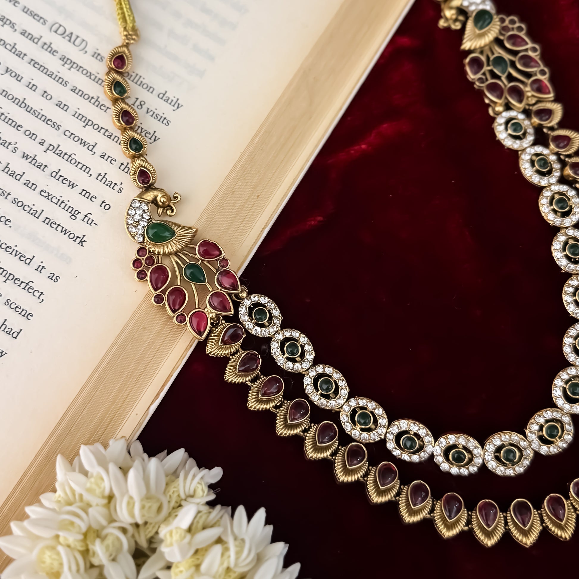 Aarna Temple premium antique gold double layer choker necklace featuring two linked tracks of concentric round green stones and a cascading bottom fringe of ruby red teardrop stones alongside matching chandelier earrings