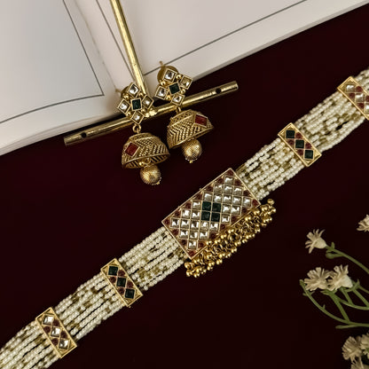 premium antique gold kundan necklace set featuring a multi strand tracking of white pearls and green beads a large central circular medallion with red and green stones and matching rectangular tiered drop earrings