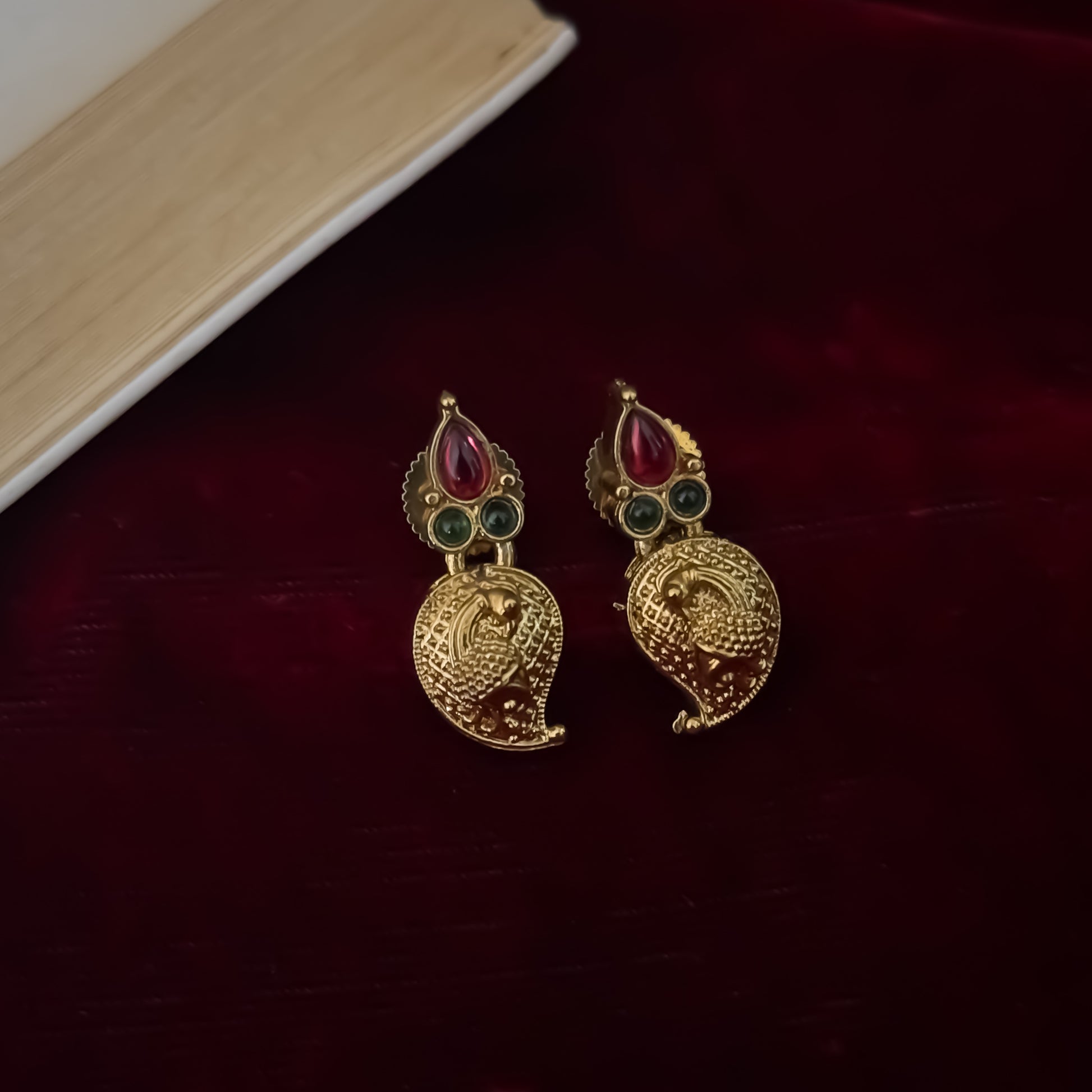 Amrapali leaf Temple gold temple choker necklace set featuring a continuous linked row of paisley manga medallions with alternating pink and green kemp stones alongside matching paisley drop earrings