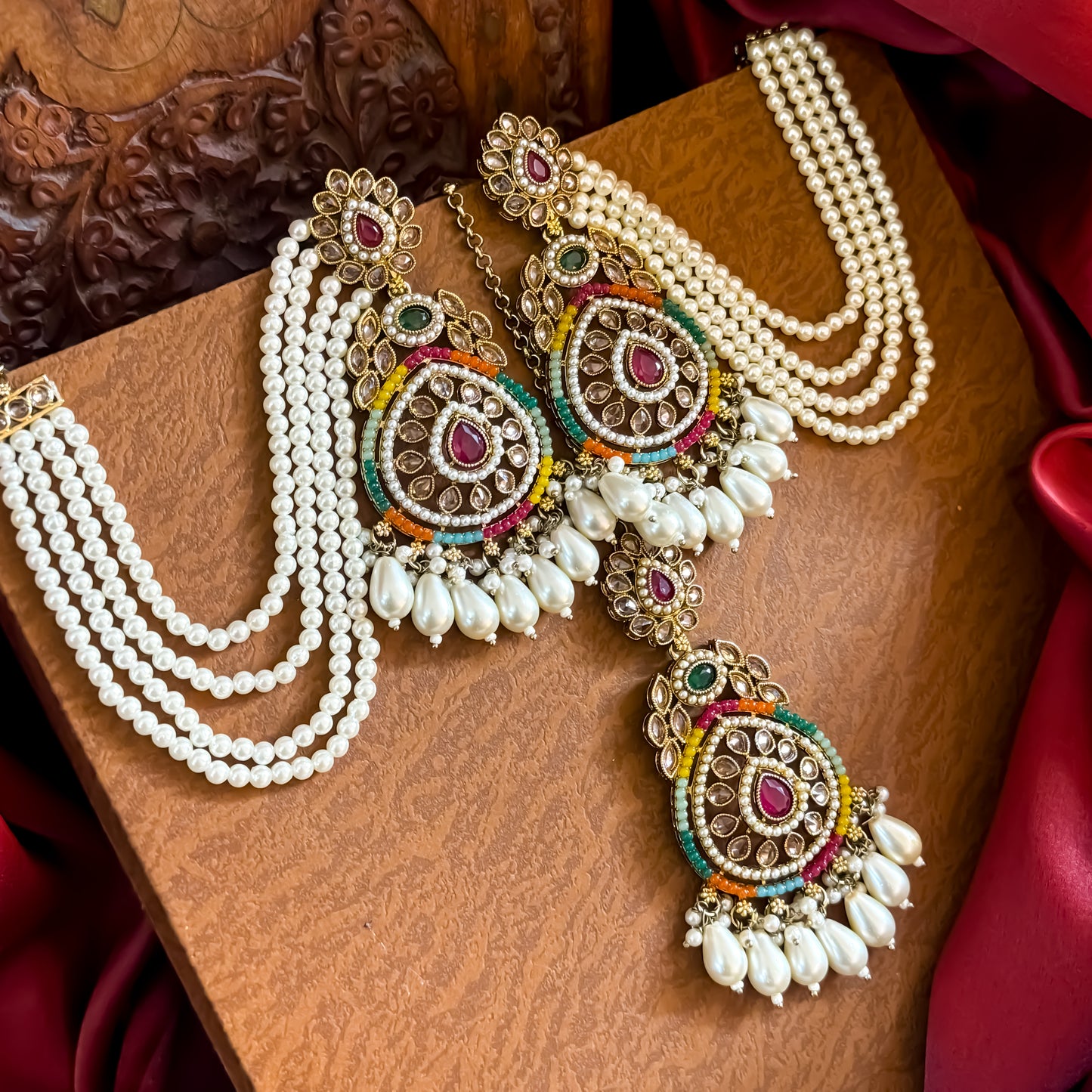Kanika premium antique gold reverse AD chandbali earrings featuring five layered pearl sahara chains and a matching multicolor maang teeka set flat lay