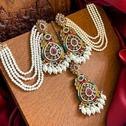 Kanika premium antique gold reverse AD chandbali earrings featuring five layered pearl sahara chains and a matching multicolor maang teeka set flat lay