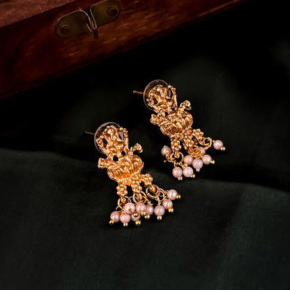 Bhavika temple jewelry hasli necklace set featuring a matte gold goddess lakshmi pendant with ruby stones and hanging green crystal drops