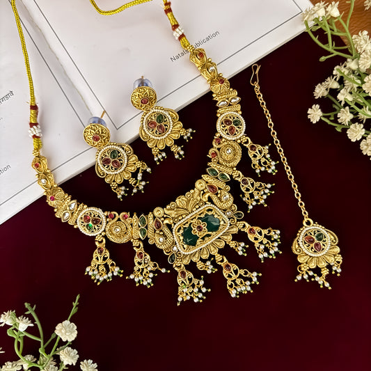 premium antique gold kundan necklace set featuring a multi strand tracking of white pearls and green beads a large central circular medallion with red and green stones and matching rectangular tiered drop earrings