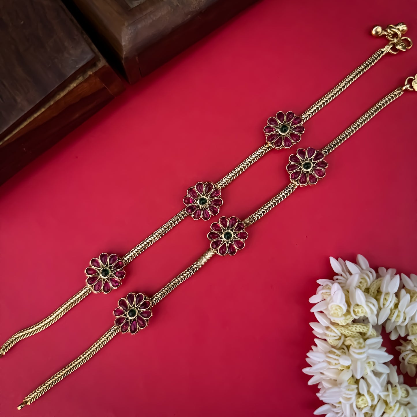 Floral Temple premium antique gold anklet pair featuring flexible double strand woven chain bands linked circular ruby pink and green kemp stone rosettes and cascading gold ghungroo fringes