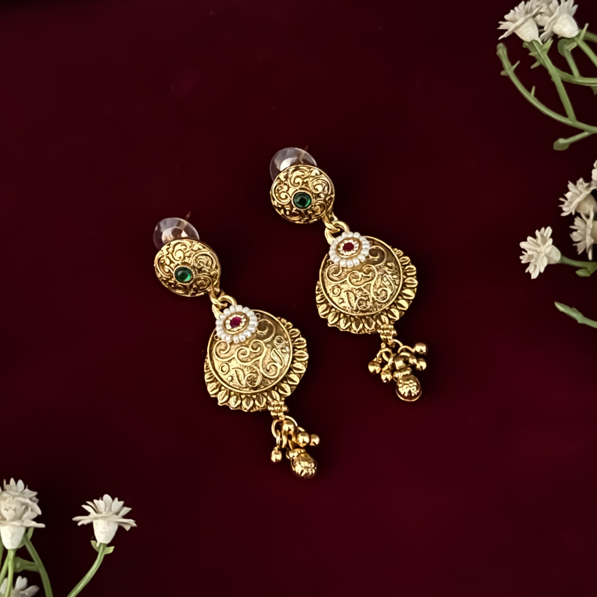 premium antique gold kundan necklace set featuring a multi strand tracking of white pearls and green beads a large central circular medallion with red and green stones and matching rectangular tiered drop earrings