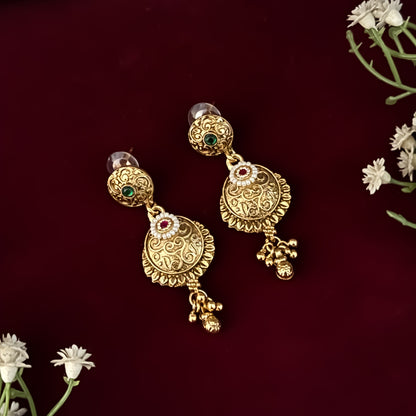 premium antique gold kundan necklace set featuring a multi strand tracking of white pearls and green beads a large central circular medallion with red and green stones and matching rectangular tiered drop earrings