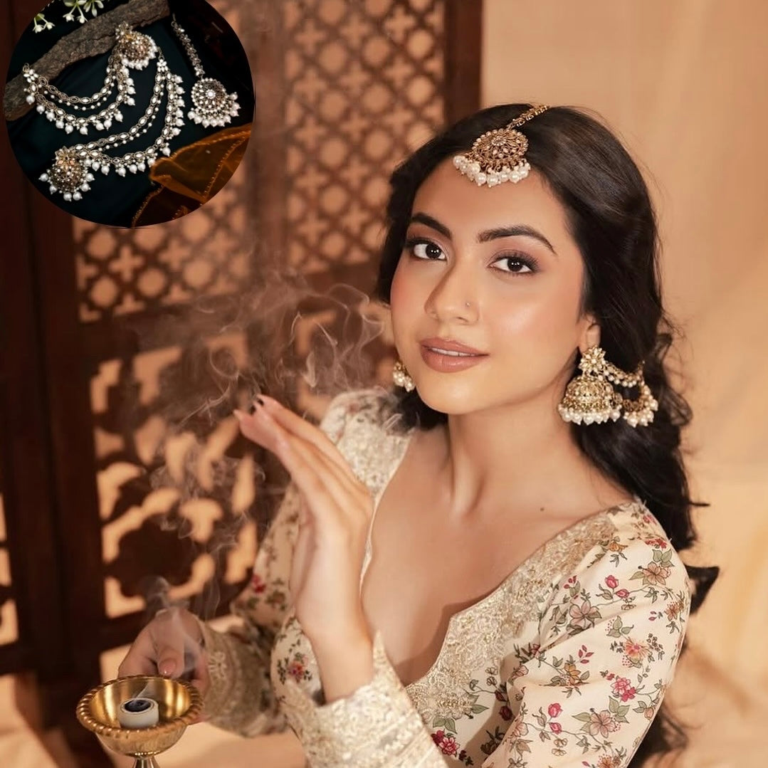Traditional antique gold kundan mirror work bridal jewelry set styled on a woman with loose dark hair wearing a cream floral embroidered lehenga blouse