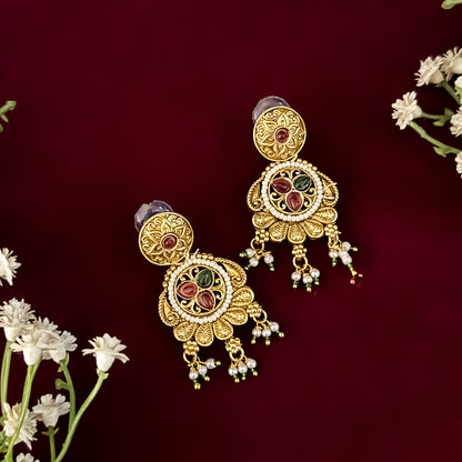 premium antique gold kundan necklace set featuring a multi strand tracking of white pearls and green beads a large central circular medallion with red and green stones and matching rectangular tiered drop earrings