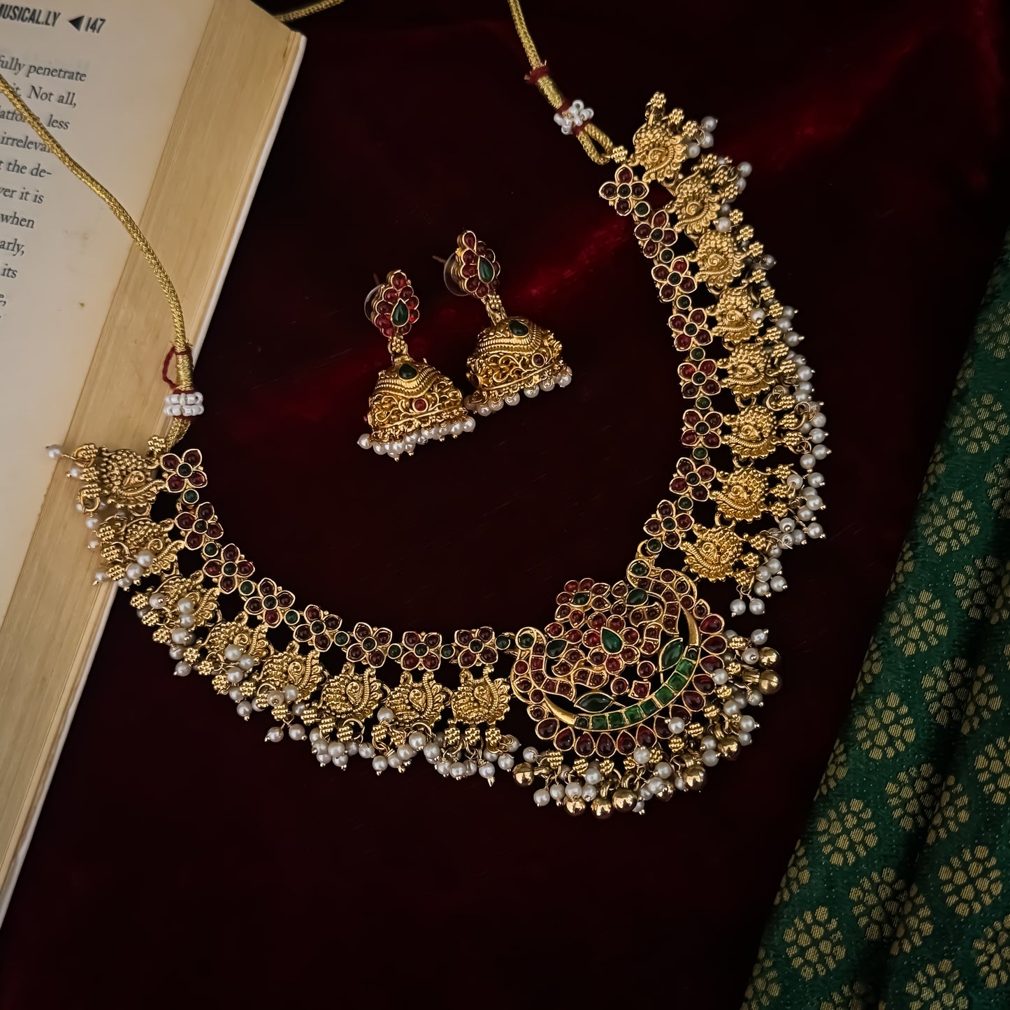 Kalyani premium antique gold temple necklace set featuring continuous rows of floral medallions crescent pendant pink and green stones and pearl drops with matching jhumkas