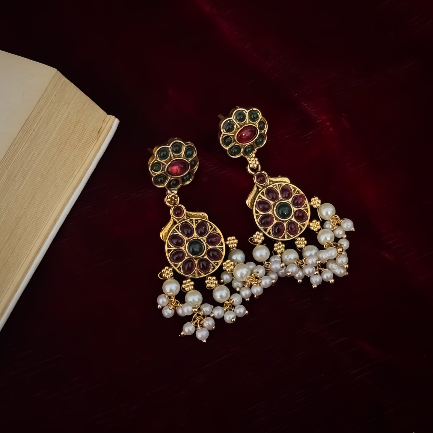Qavithri premium antique gold temple choker necklace set featuring a guttapusalu multi strand white pearl cluster fringe with clear pink and green kemp stones alongside matching tiered chakra drop earrings