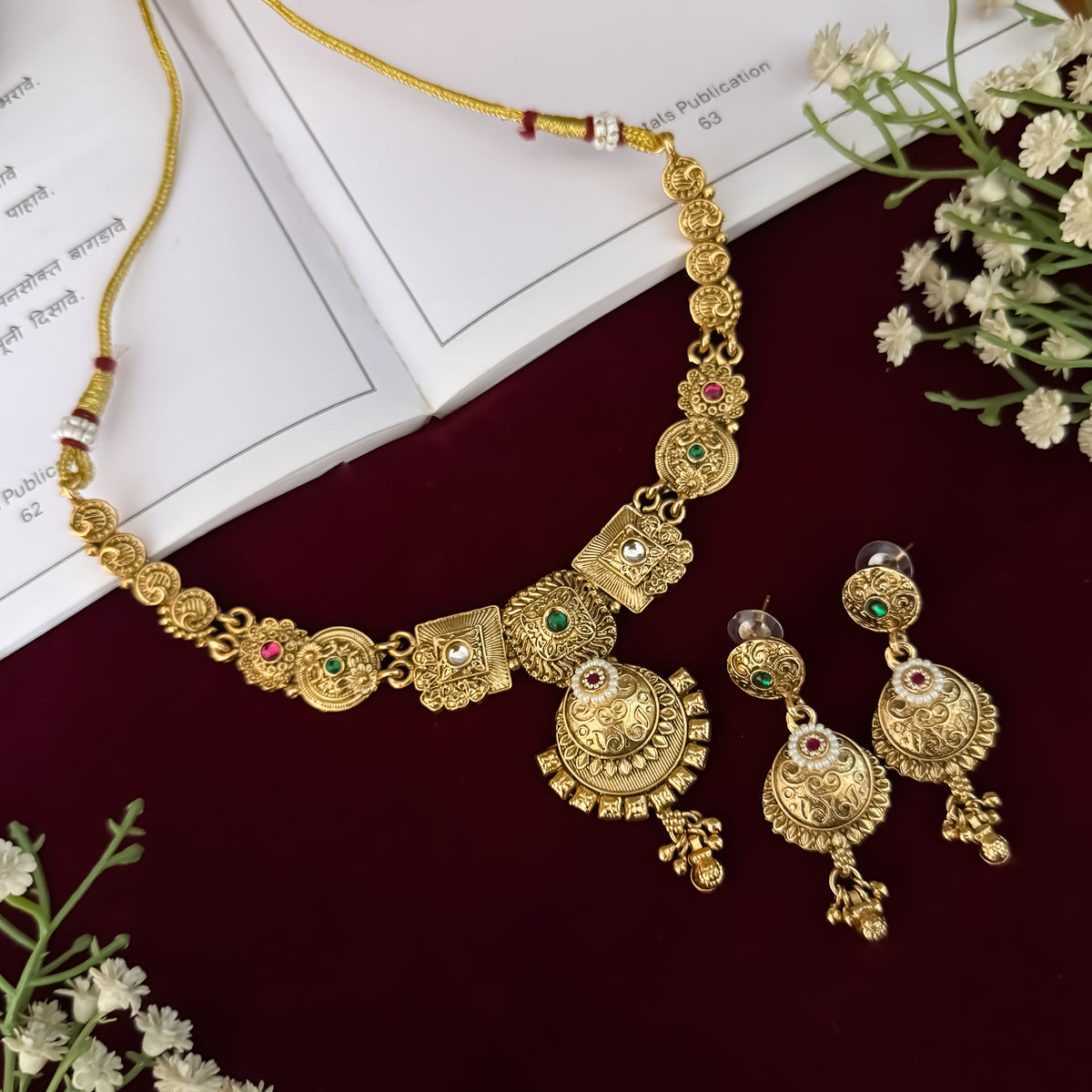 premium antique gold kundan necklace set featuring a multi strand tracking of white pearls and green beads a large central circular medallion with red and green stones and matching rectangular tiered drop earrings