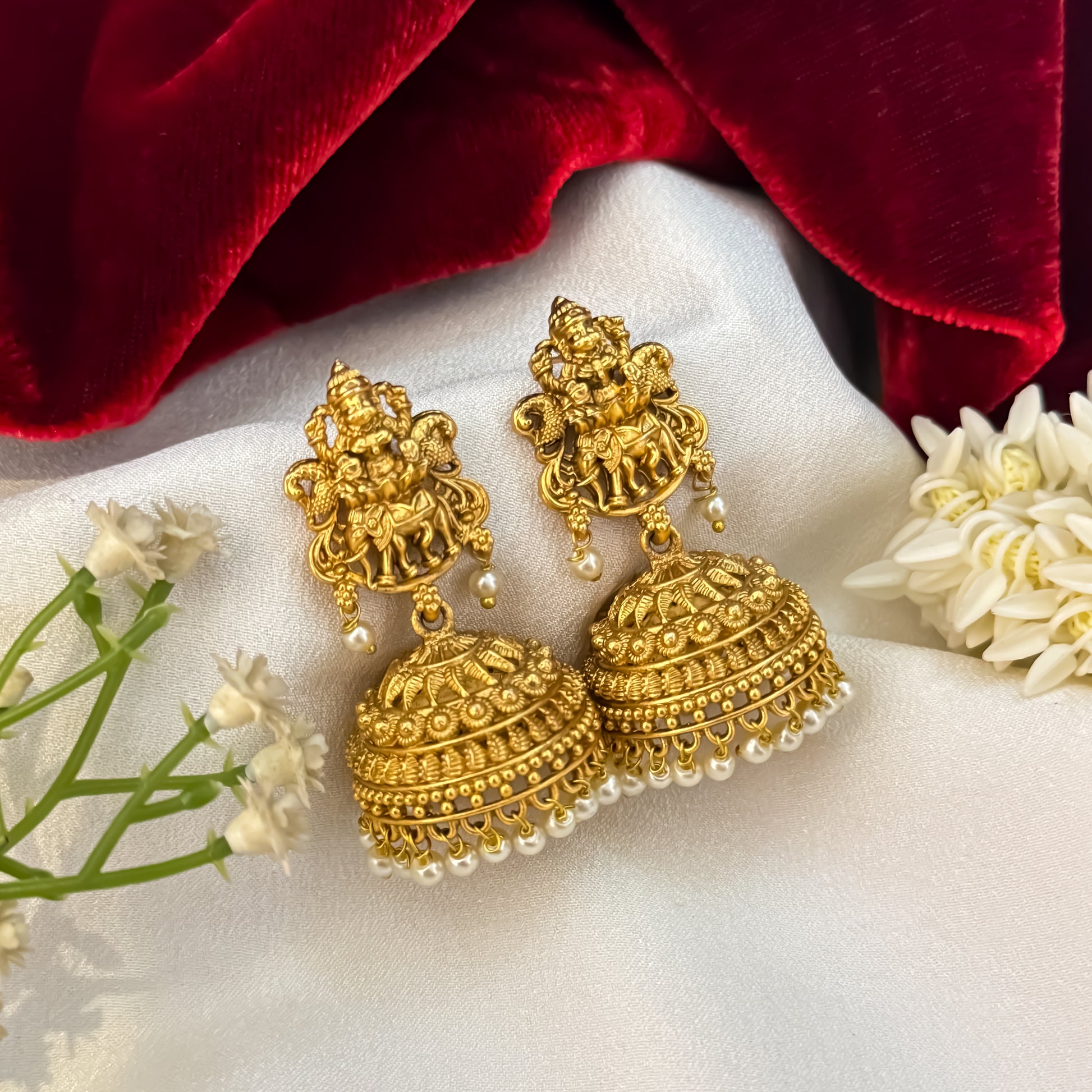 Temple Motif Jhumka Earrings featuring premium antique gold Goddess Lakshmi and peacock top studs holding a wide flared dome cup with a dense cascading white seed pearl fringe