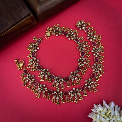 Floral Temple premium antique gold anklet pair featuring flexible double strand woven chain bands linked circular ruby pink and green kemp stone rosettes and cascading gold ghungroo fringes