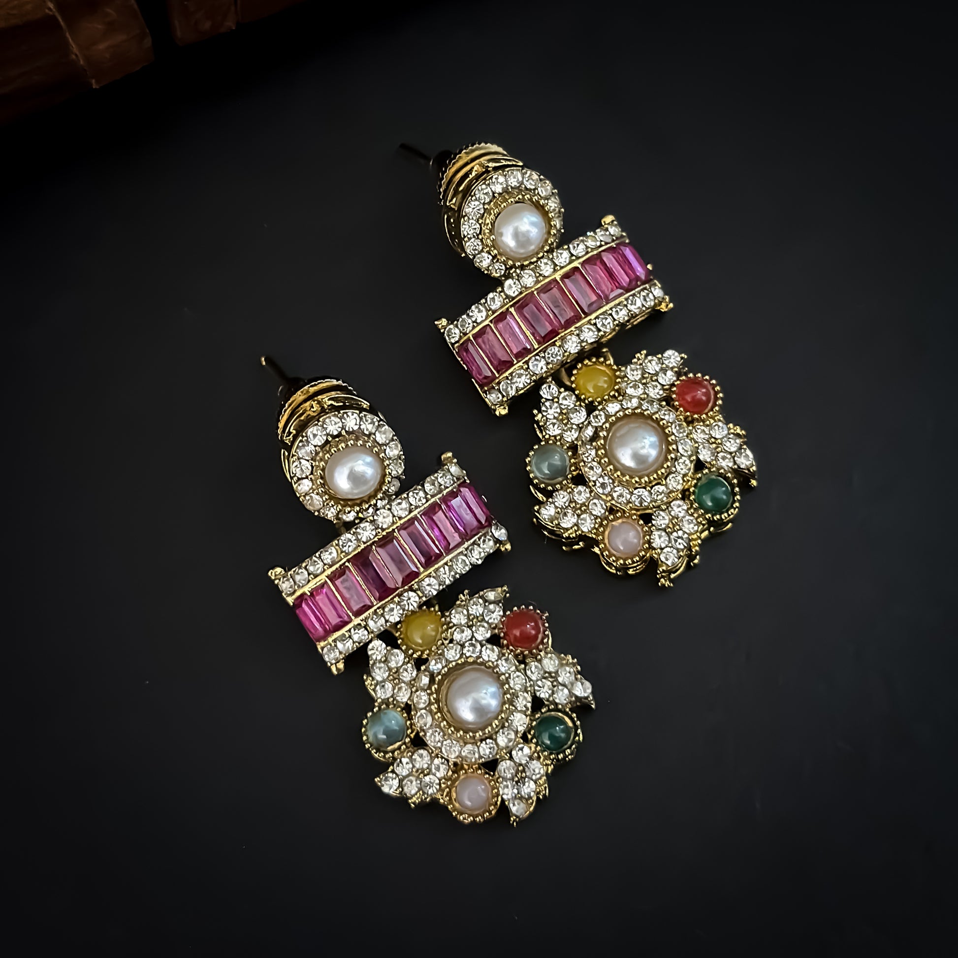 Ashwini Sabyasachi style premium antique gold kundan multi color necklace set featuring a segmented panel collar tracking of multi shape multicolored gemstone baguettes sunburst kundan rosettes white pearls matching tiered earrings and maang tikka
