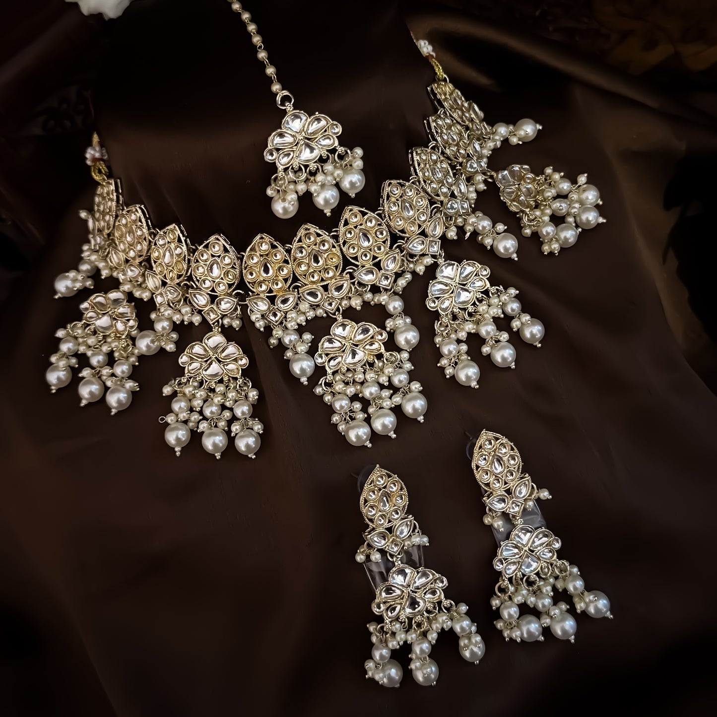 premium antique gold kundan broad choker necklace set featuring a linear linked tracking of crescent chandbali medallions dense white cluster pearl fringes matching chandelier earrings and maang tikka