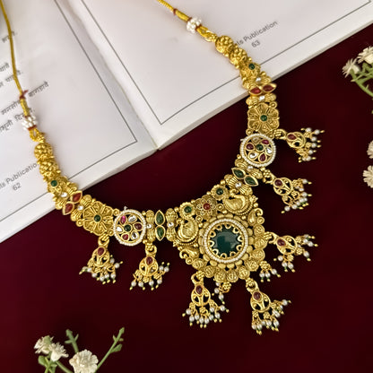 premium antique gold kundan necklace set featuring a multi strand tracking of white pearls and green beads a large central circular medallion with red and green stones and matching rectangular tiered drop earrings