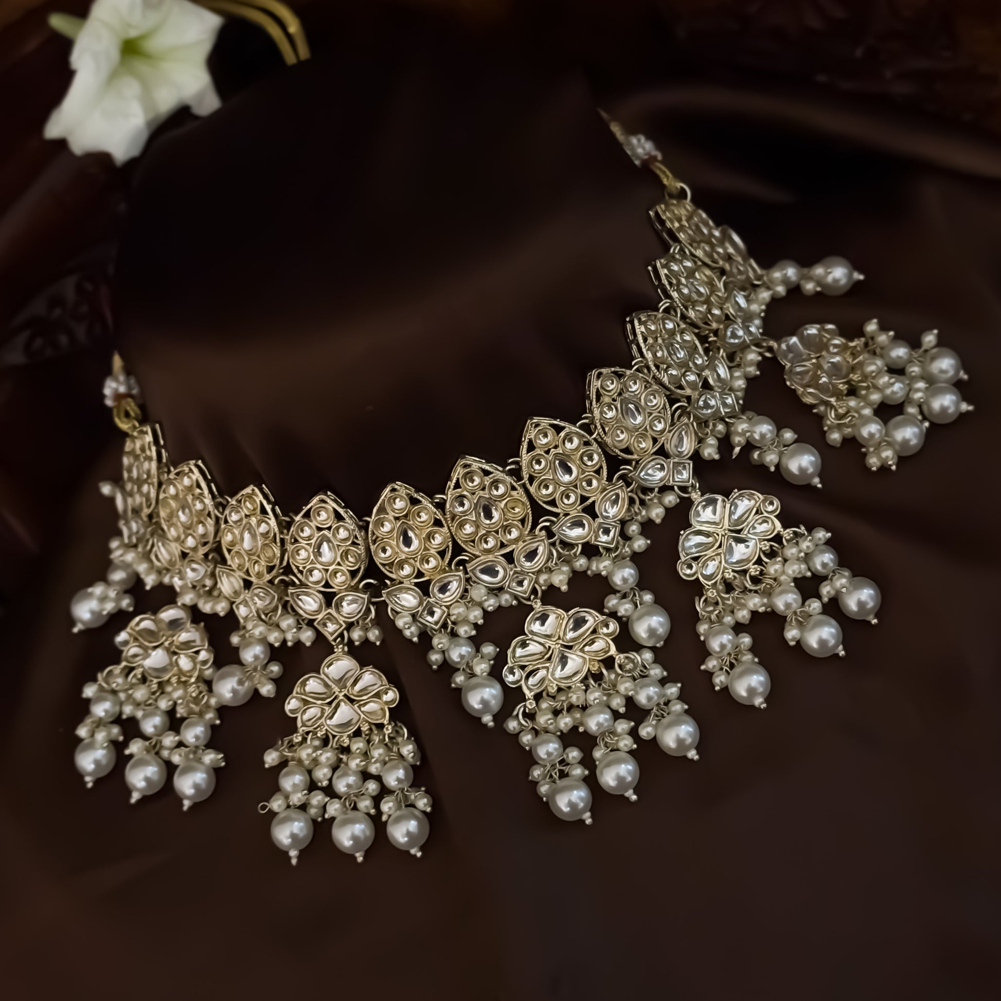 premium antique gold kundan broad choker necklace set featuring a linear linked tracking of crescent chandbali medallions dense white cluster pearl fringes matching chandelier earrings and maang tikka