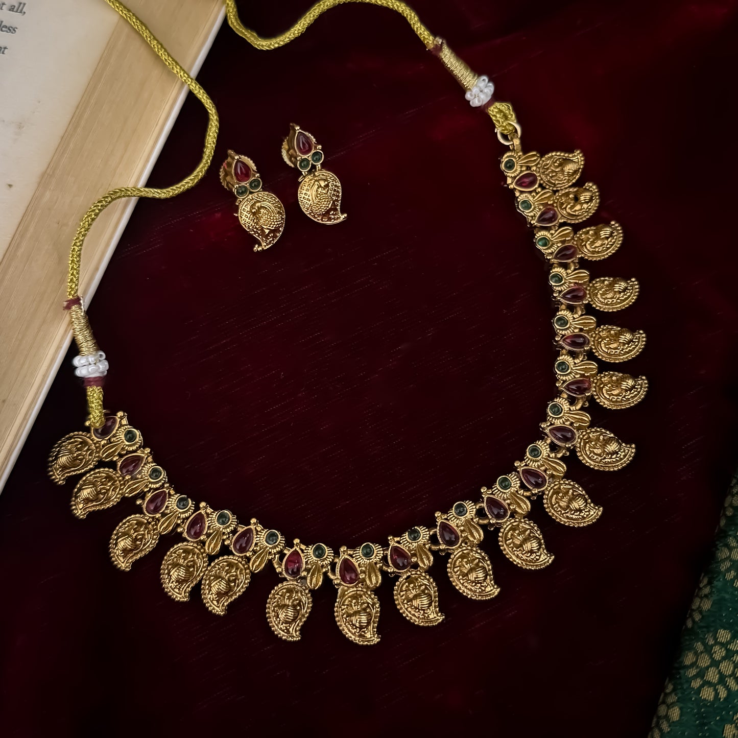 Amrapali leaf Temple gold temple choker necklace set featuring a continuous linked row of paisley manga medallions with alternating pink and green kemp stones alongside matching paisley drop earrings