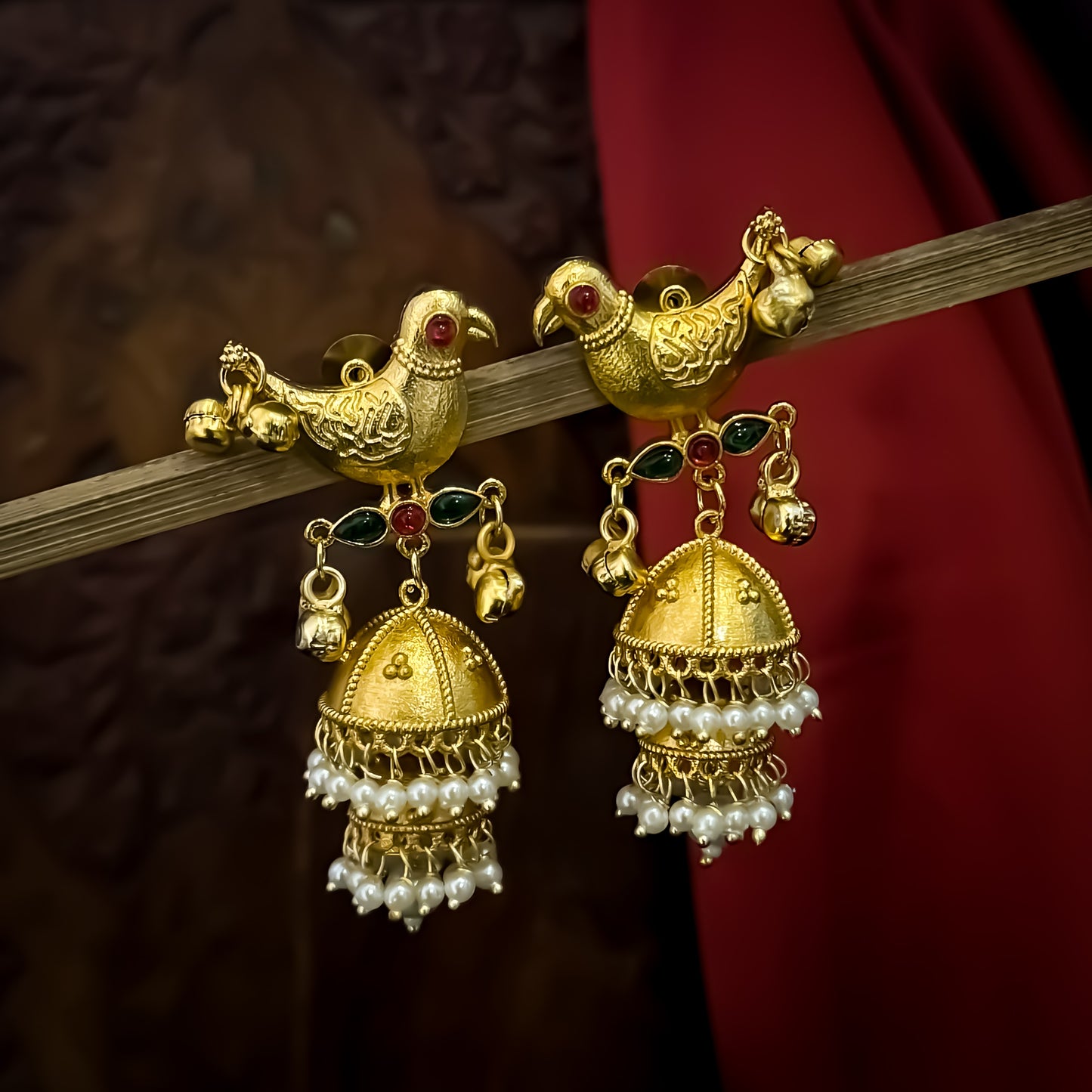 Totapari premium kashmiri brass jhumka earrings featuring sculpted gold peacock studs red and green stone links and three tiered pearl domes