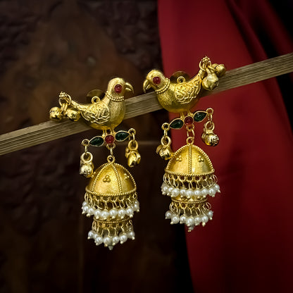 Totapari premium kashmiri brass jhumka earrings featuring sculpted gold peacock studs red and green stone links and three tiered pearl domes