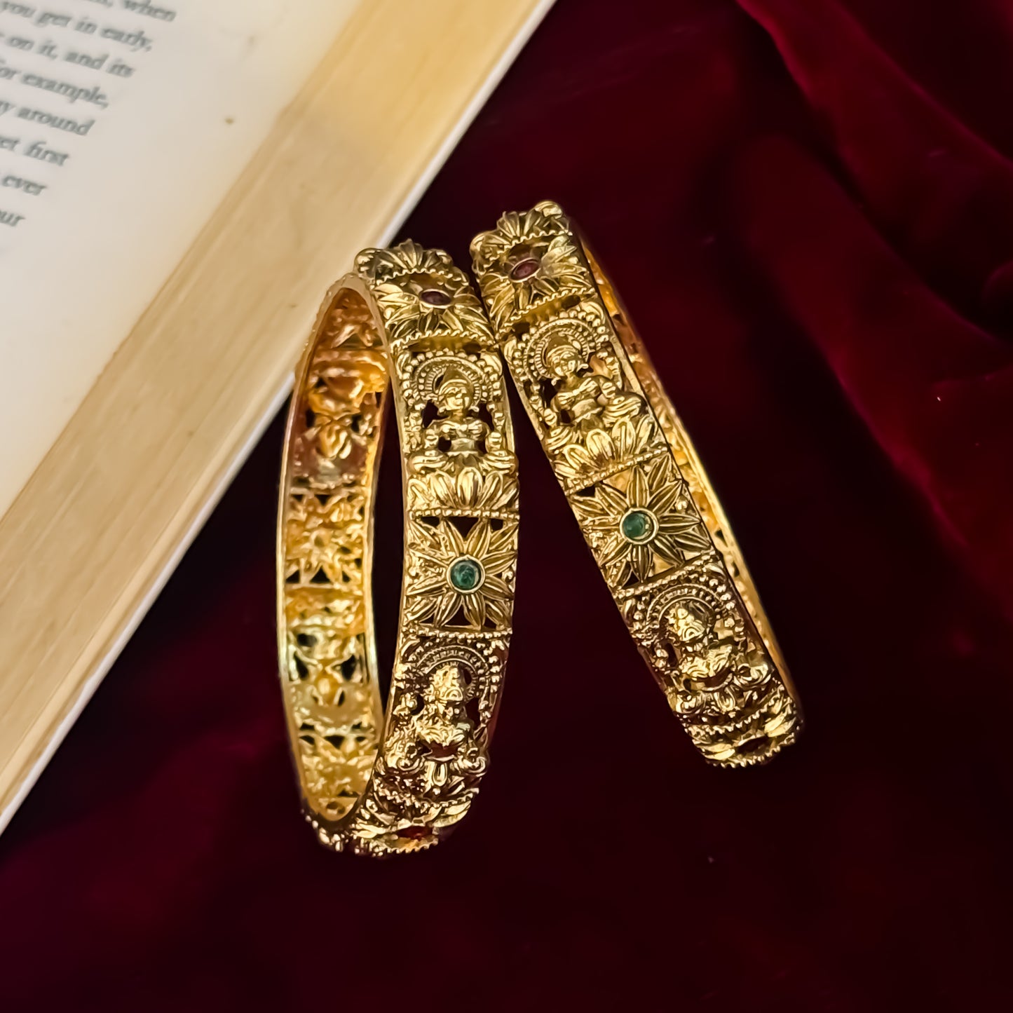 premium antique gold temple bangles featuring continuous rows of sculpted goddess lakshmi motifs square green stones and maroon halos