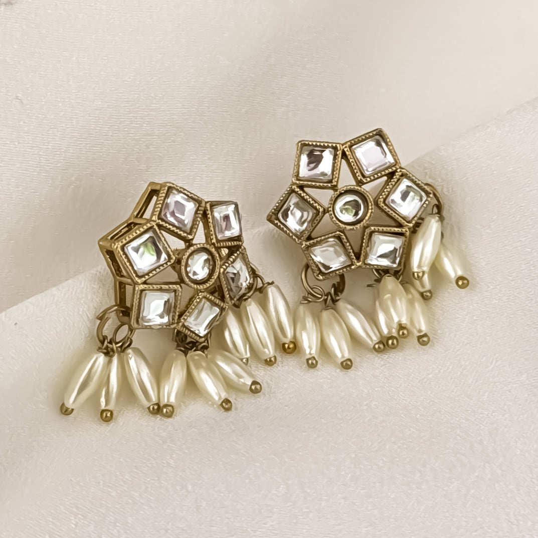 Yashvi premium antique gold kundan sleek collar necklace set featuring a linear linked tracking of clear dabi stones and a dense cascading fringe of white rice pearls with matching hexagonal stud earrings and maang tikka