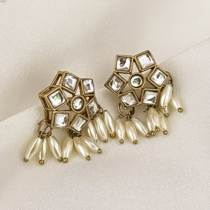 Yashvi premium antique gold kundan sleek collar necklace set featuring a linear linked tracking of clear dabi stones and a dense cascading fringe of white rice pearls with matching hexagonal stud earrings and maang tikka