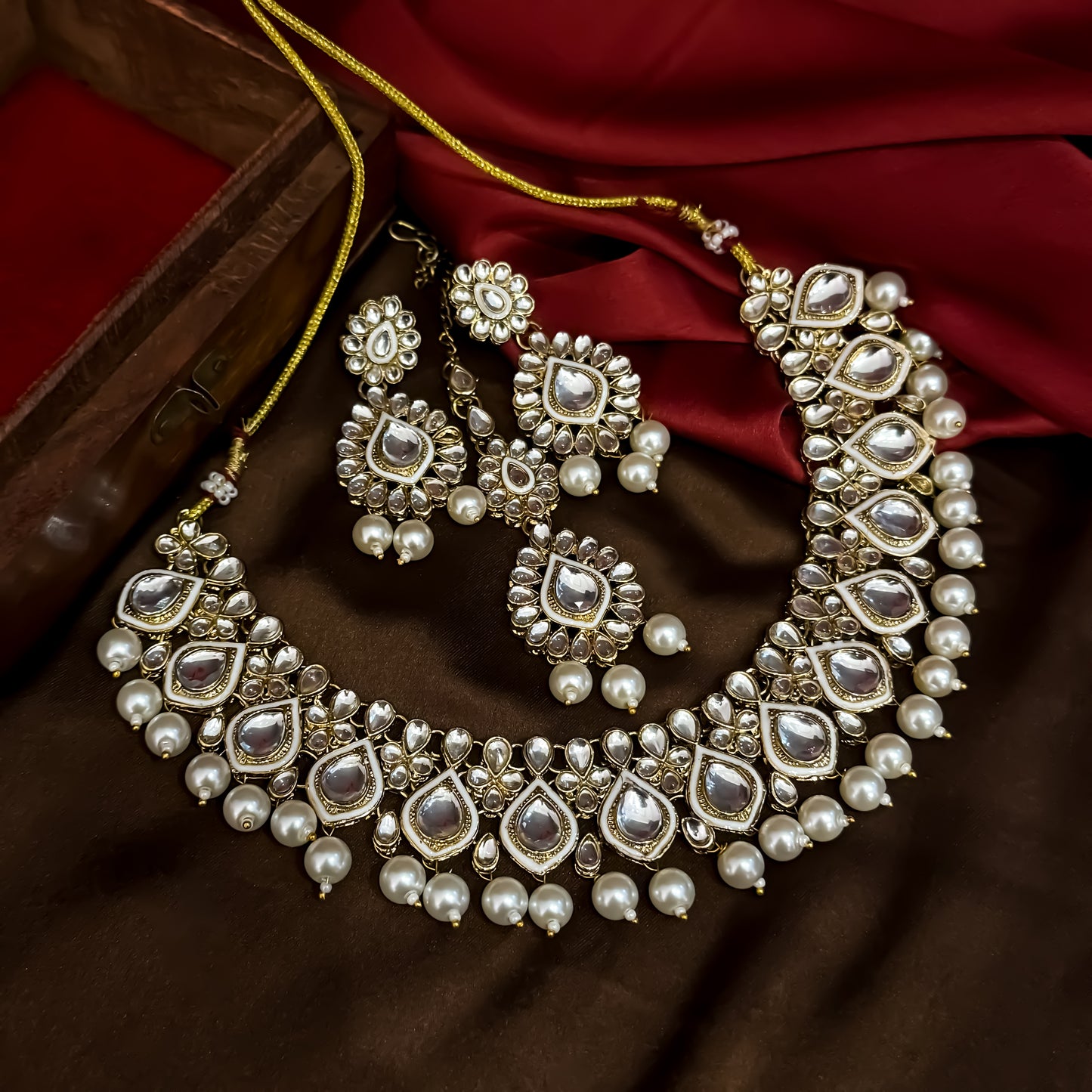 Kumud premium antique gold kundan choker necklace set featuring emerald green enamel borders and hanging white pearl drops with matching earrings and maang teeka