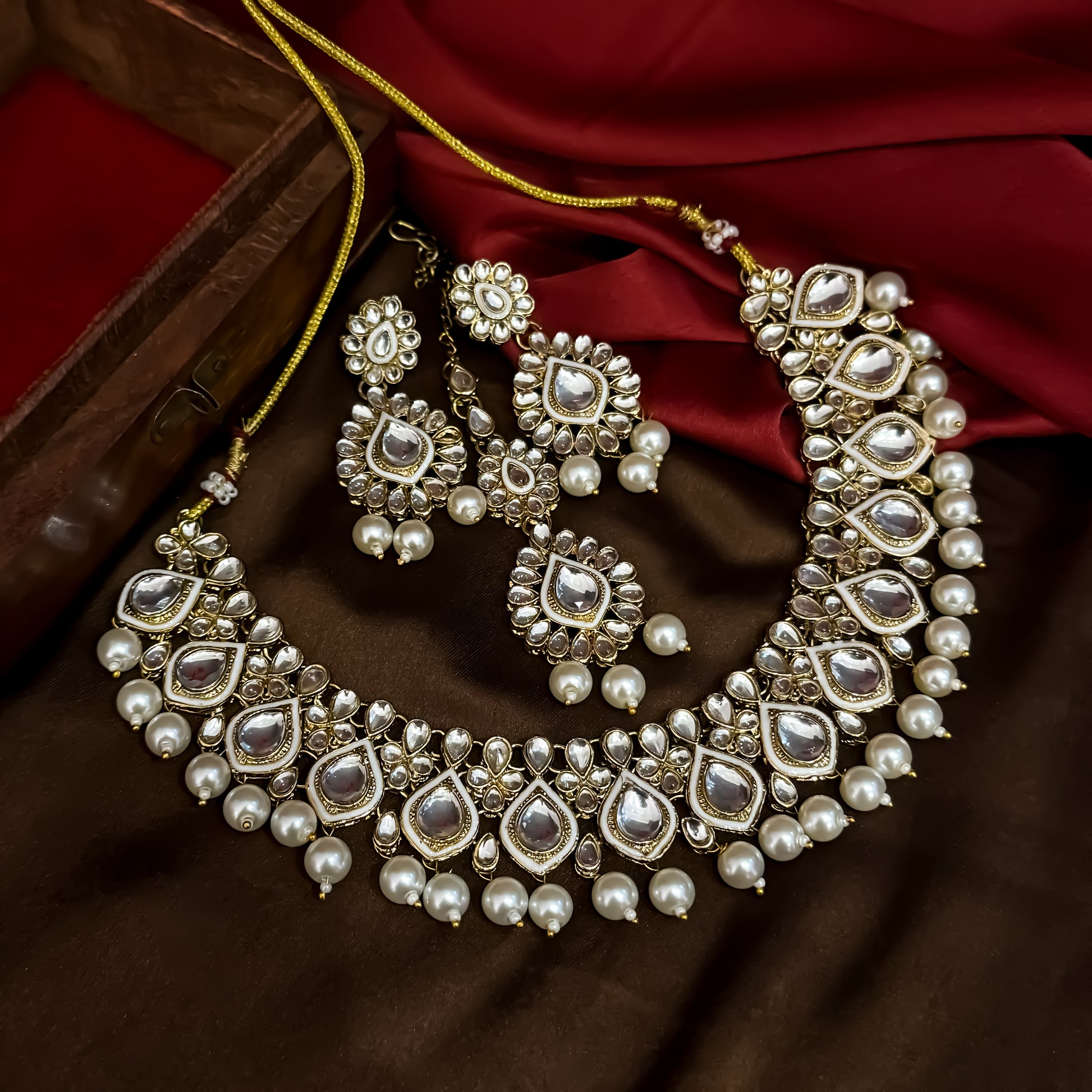 Kumud premium antique gold kundan choker necklace set featuring emerald green enamel borders and hanging white pearl drops with matching earrings and maang teeka