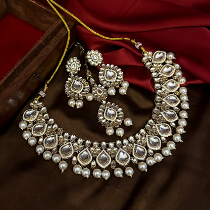 Kumud premium antique gold kundan choker necklace set featuring emerald green enamel borders and hanging white pearl drops with matching earrings and maang teeka