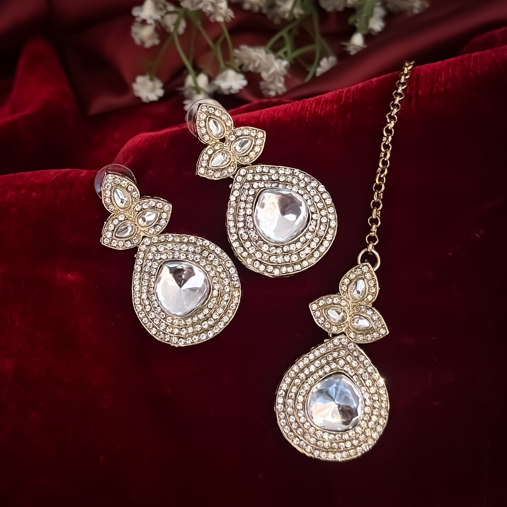 Rashmika premium antique gold kundan triple layer necklace set featuring three parallel cascading tracks of clear dabi mock polki stones a central teardrop pendant line matching drop earrings and maang tikka