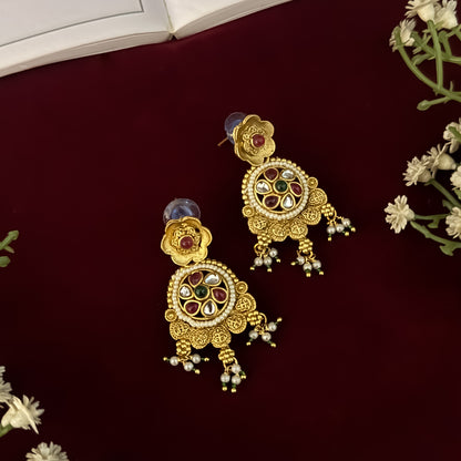premium antique gold kundan necklace set featuring a multi strand tracking of white pearls and green beads a large central circular medallion with red and green stones and matching rectangular tiered drop earrings