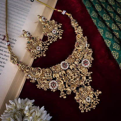 Avani Temple premium antique gold choker necklace featuring a broad central stacked pendant encrusted with pink and green kemp stones twin peacocks a gold ghungroo fringe and matching dome jhumka earrings