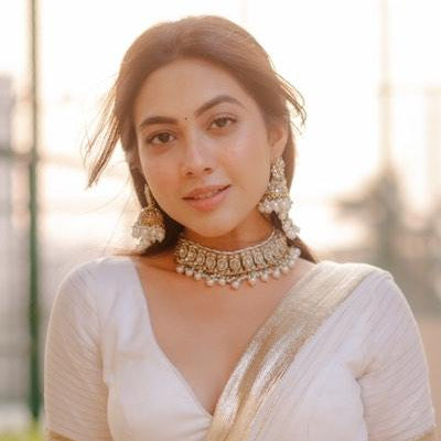 Reem premium antique gold kundan broad choker necklace set featuring a central crescent flower rosette medallion multi strand woven white pearl bands and matching chandelier earrings with detachable multi layer sahara hair chains