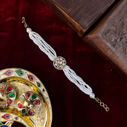 Rushali adjustable antique gold bracelet featuring a round floral blooming kundan medallion and a six strand micro pearl band