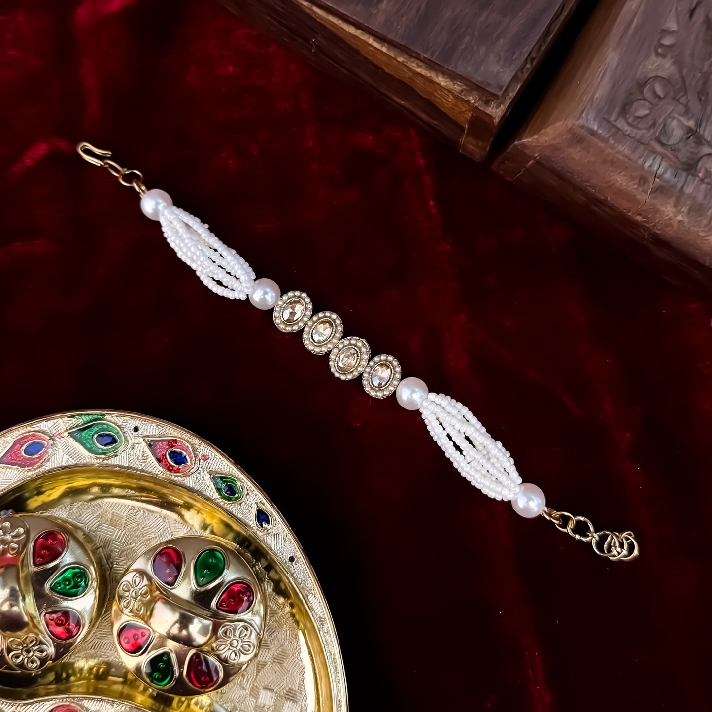 Rene adjustable antique gold polki bracelet featuring four alternating oval and teardrop links with clear cz halos and a multi strand pearl band