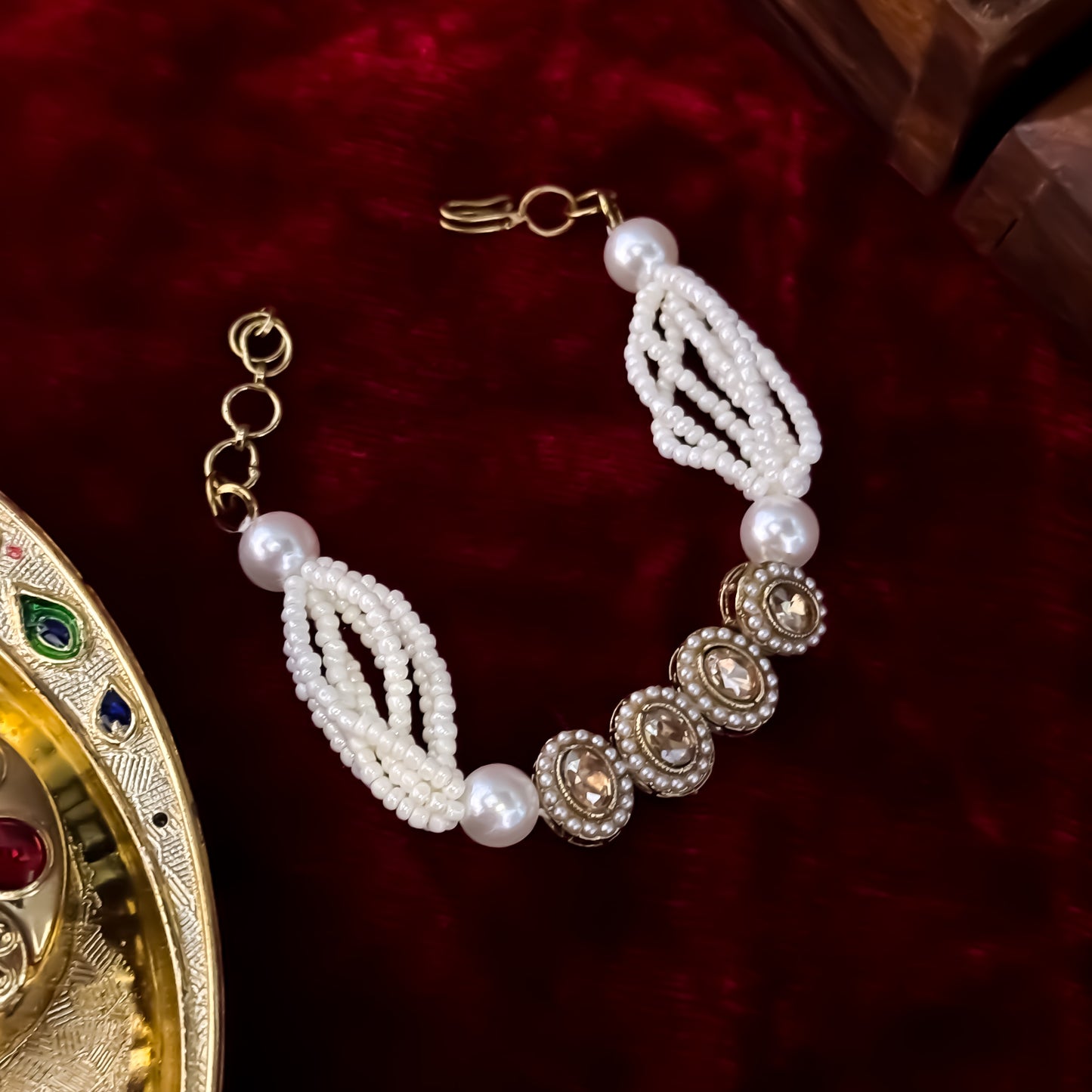 Rene adjustable antique gold polki bracelet featuring four alternating oval and teardrop links with clear cz halos and a multi strand pearl band