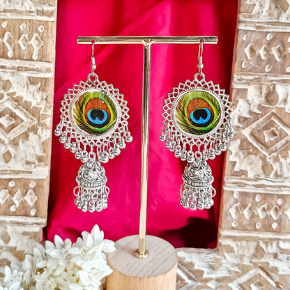 Dhriti premium oxidized silver jhumka earrings featuring circular lace sunburst medallions encased real peacock feathers and swinging ghungroo domes