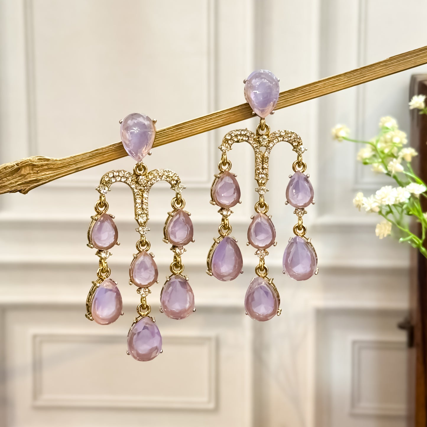 Sharon premium gold chandelier earrings featuring a micro pave crystal arch and cascading tracks of pastel lavender teardrop crystals