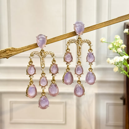 Sharon premium gold chandelier earrings featuring a micro pave crystal arch and cascading tracks of pastel lavender teardrop crystals